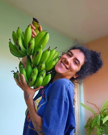 xRainbow Rafa Beleze holding a fresh bunch of bananas.